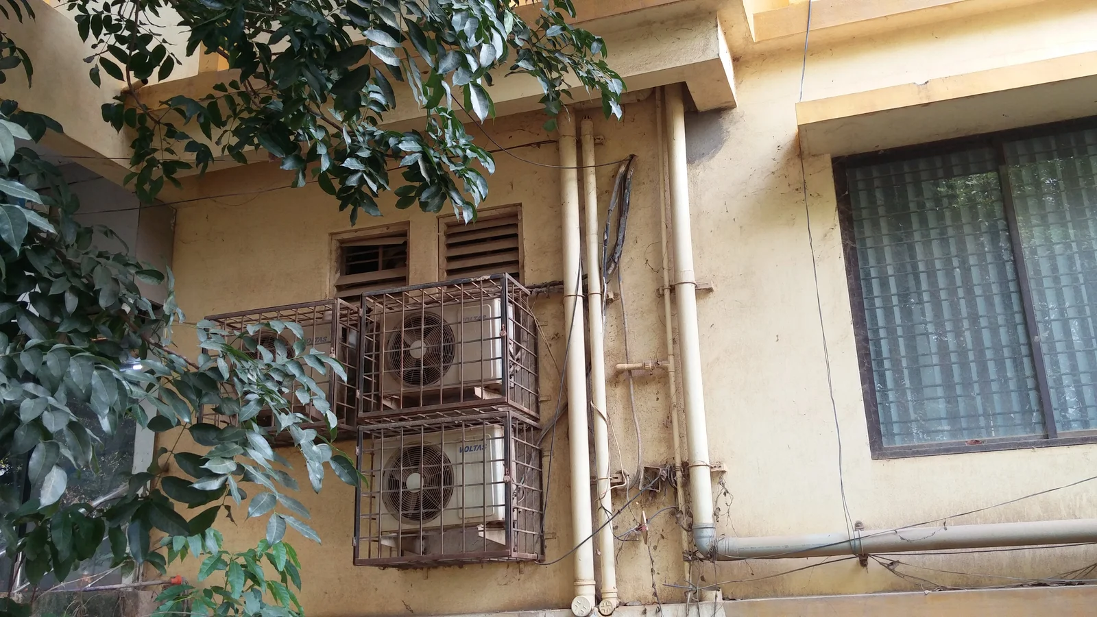 Outdoor air-conditioning units mounted on a building in Munnekollala, photographed in July 2021.