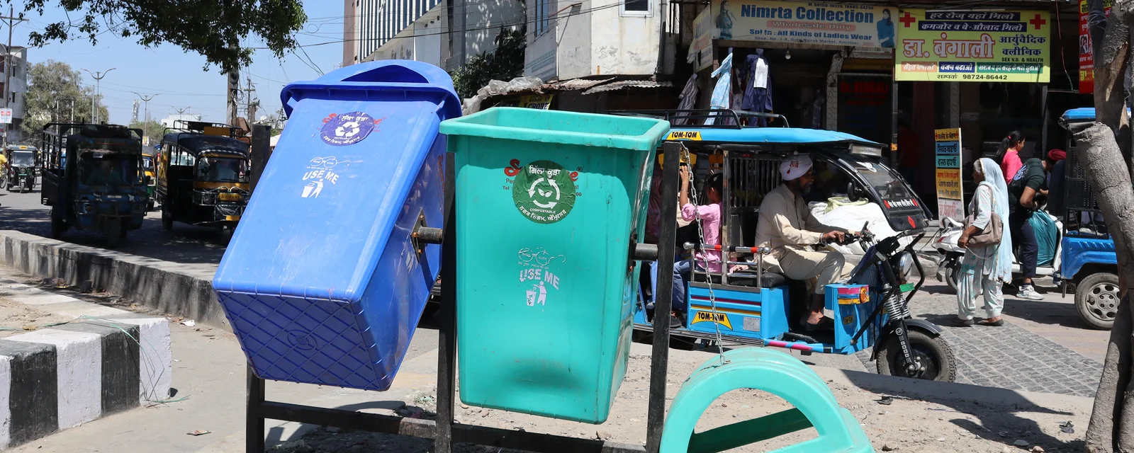 Blue and green public waste bins on an Amritsar street, photographed in April 2023.